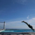 Mann springt mit einem Kopfsprung in einen kalten Pool